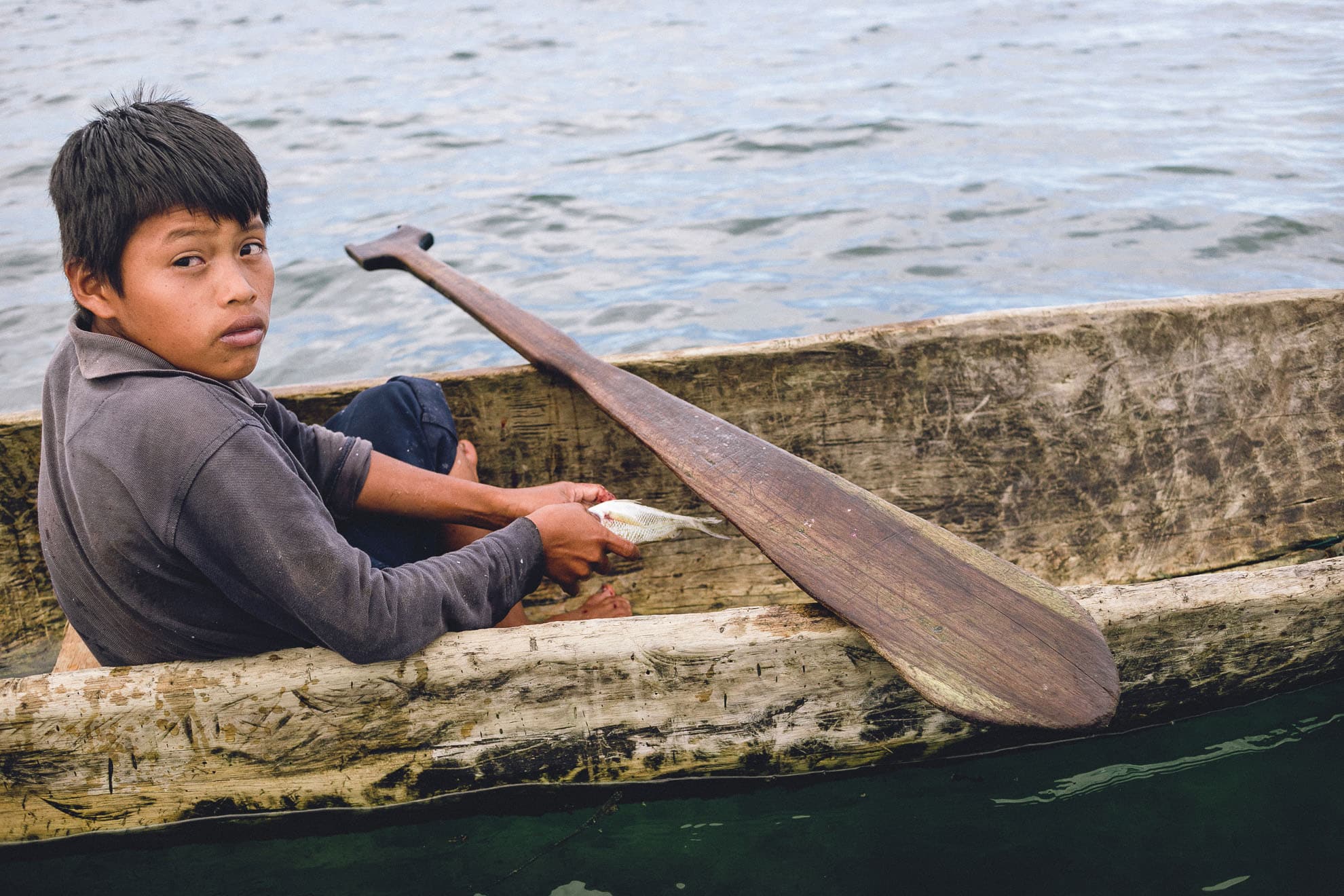 Boy fishing in canoe in Bocas del Toro