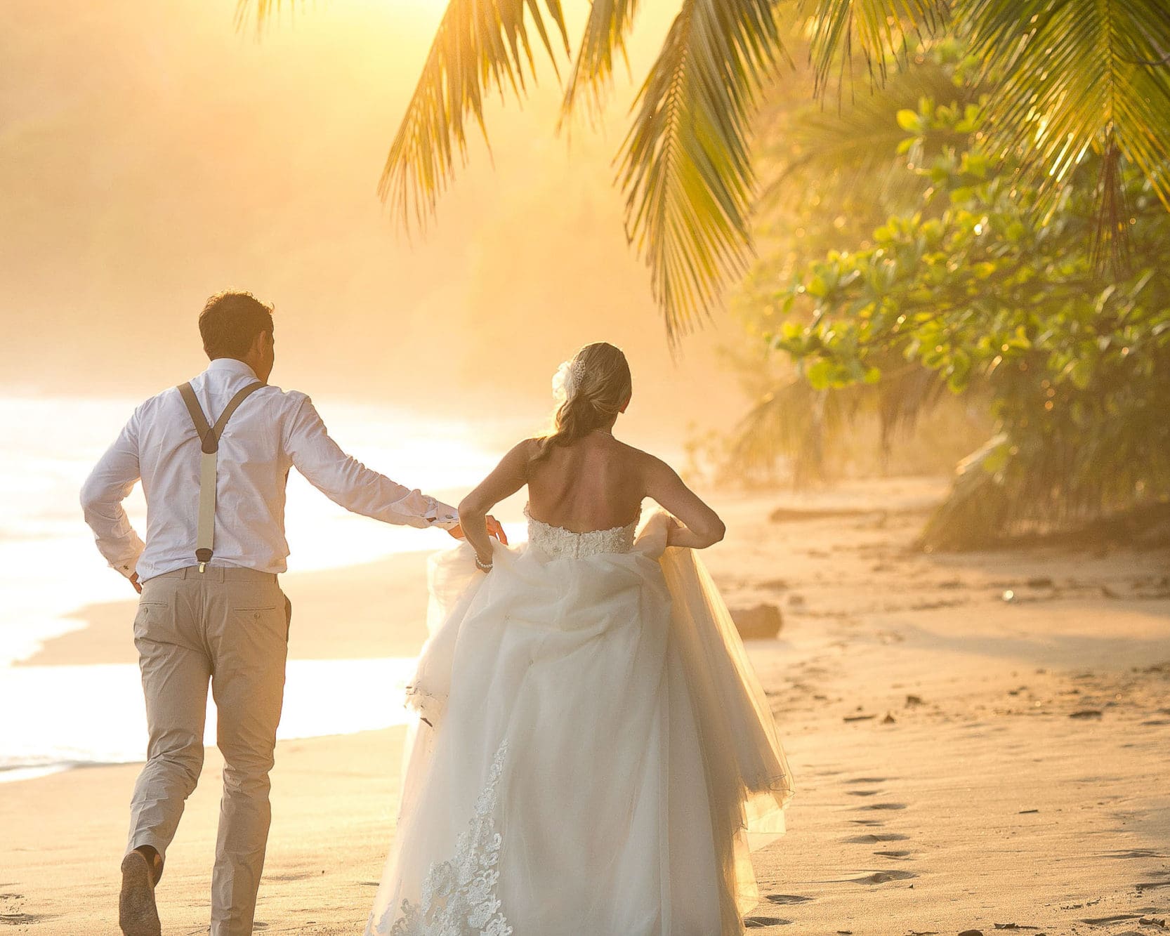 Wedding couple running during sunset.