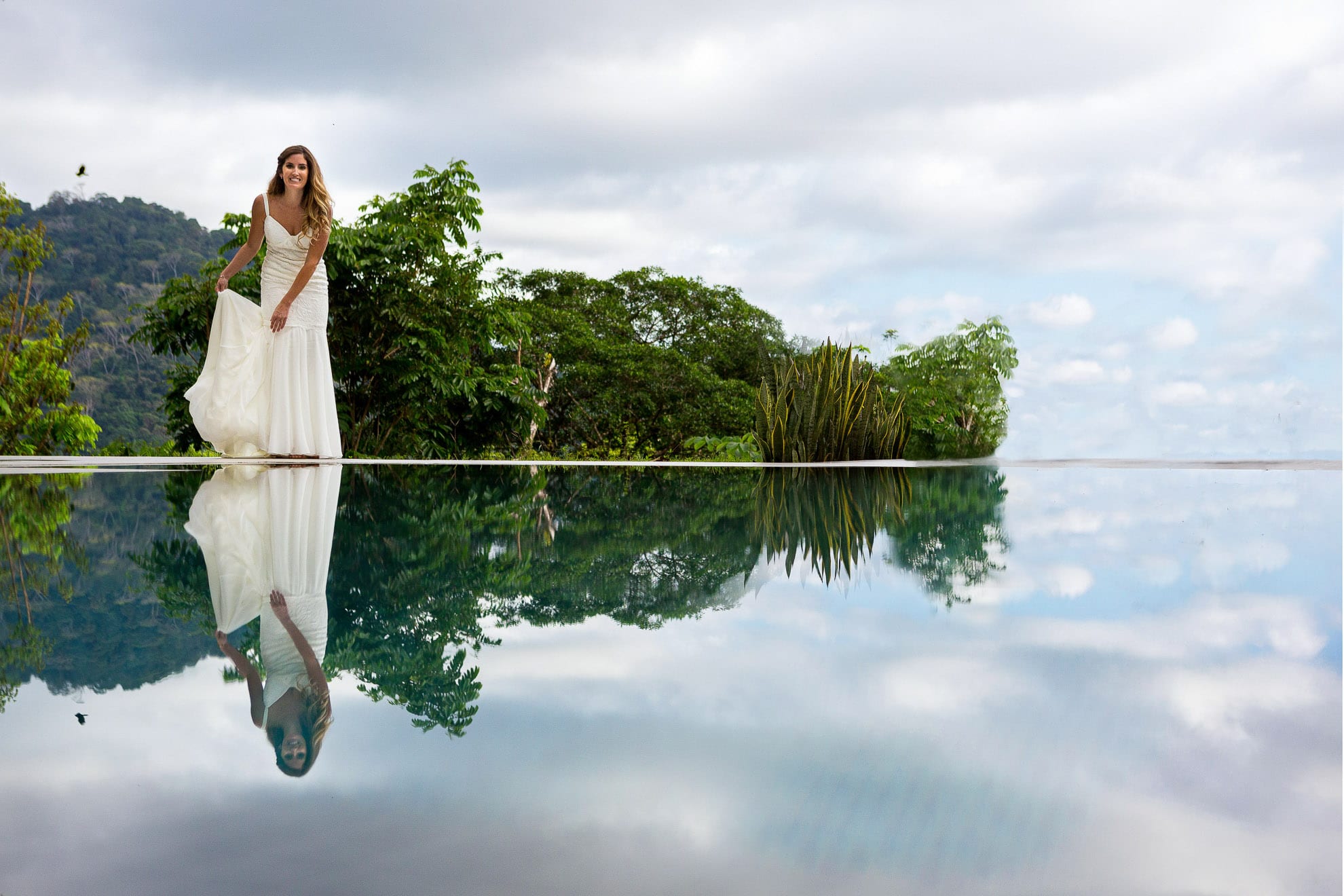 Bride reflection in infinity pool. Wedding in nature setting