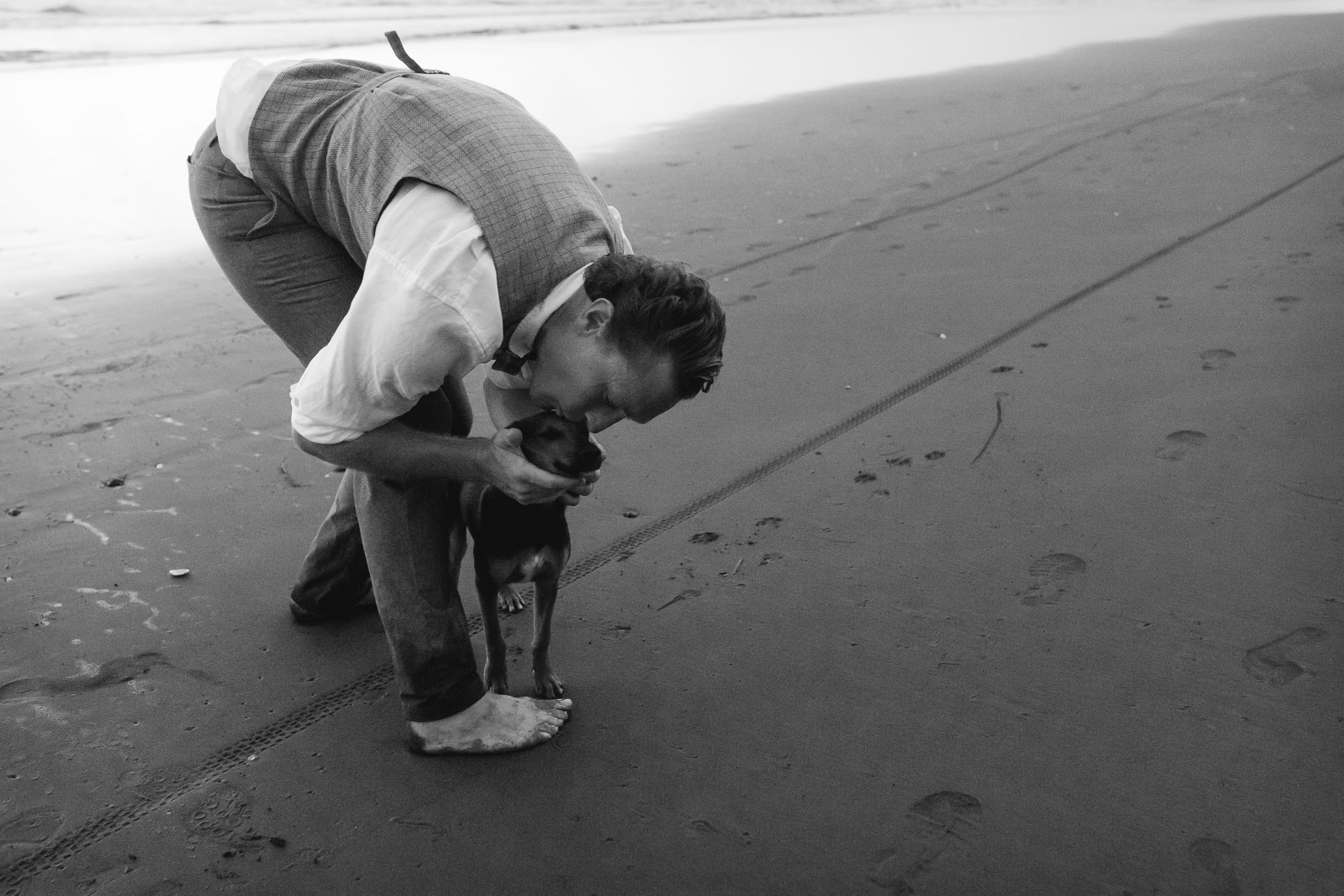 groom with dog on beach