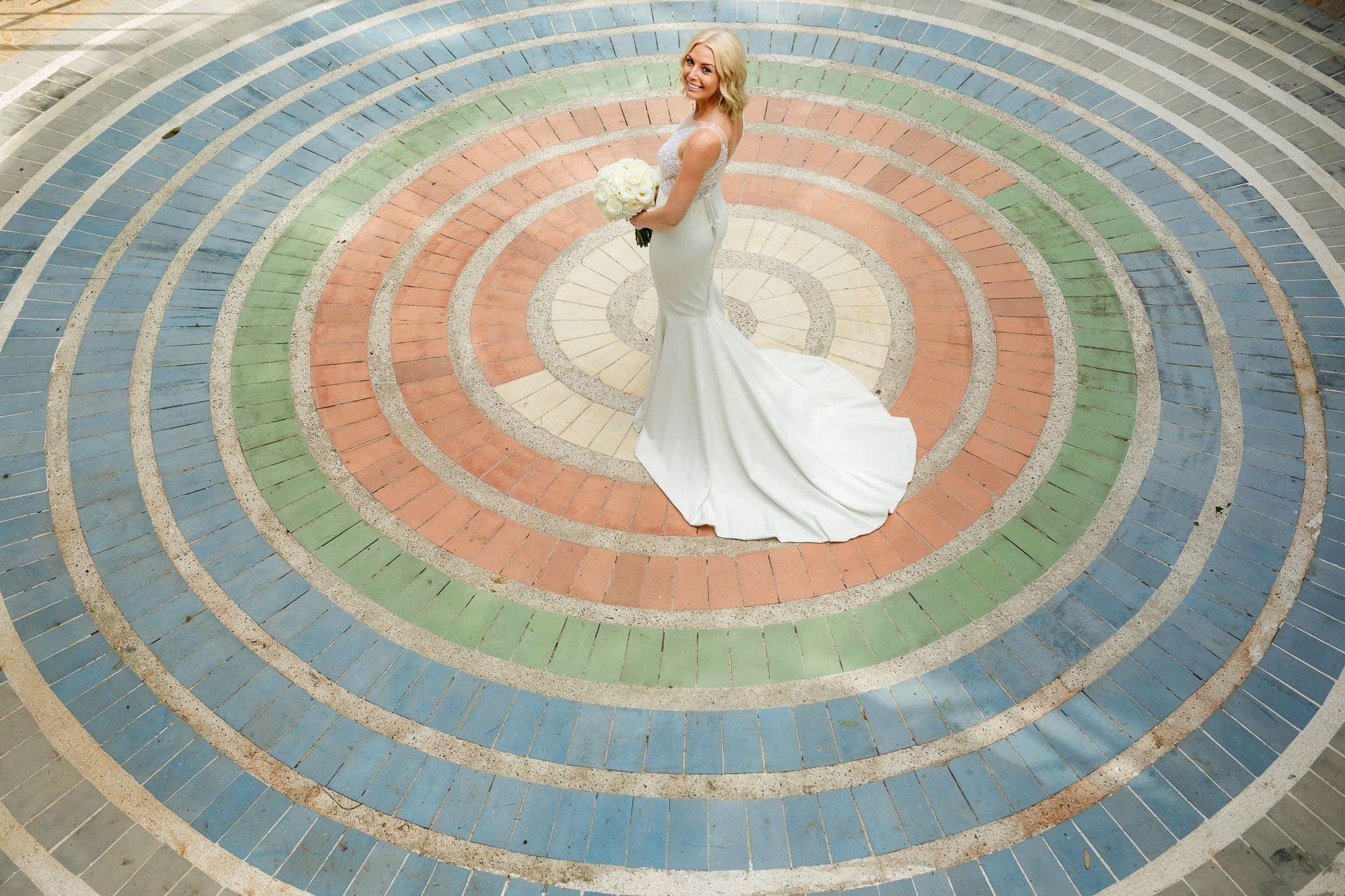 The bride at the center of a circular colored brick pattern