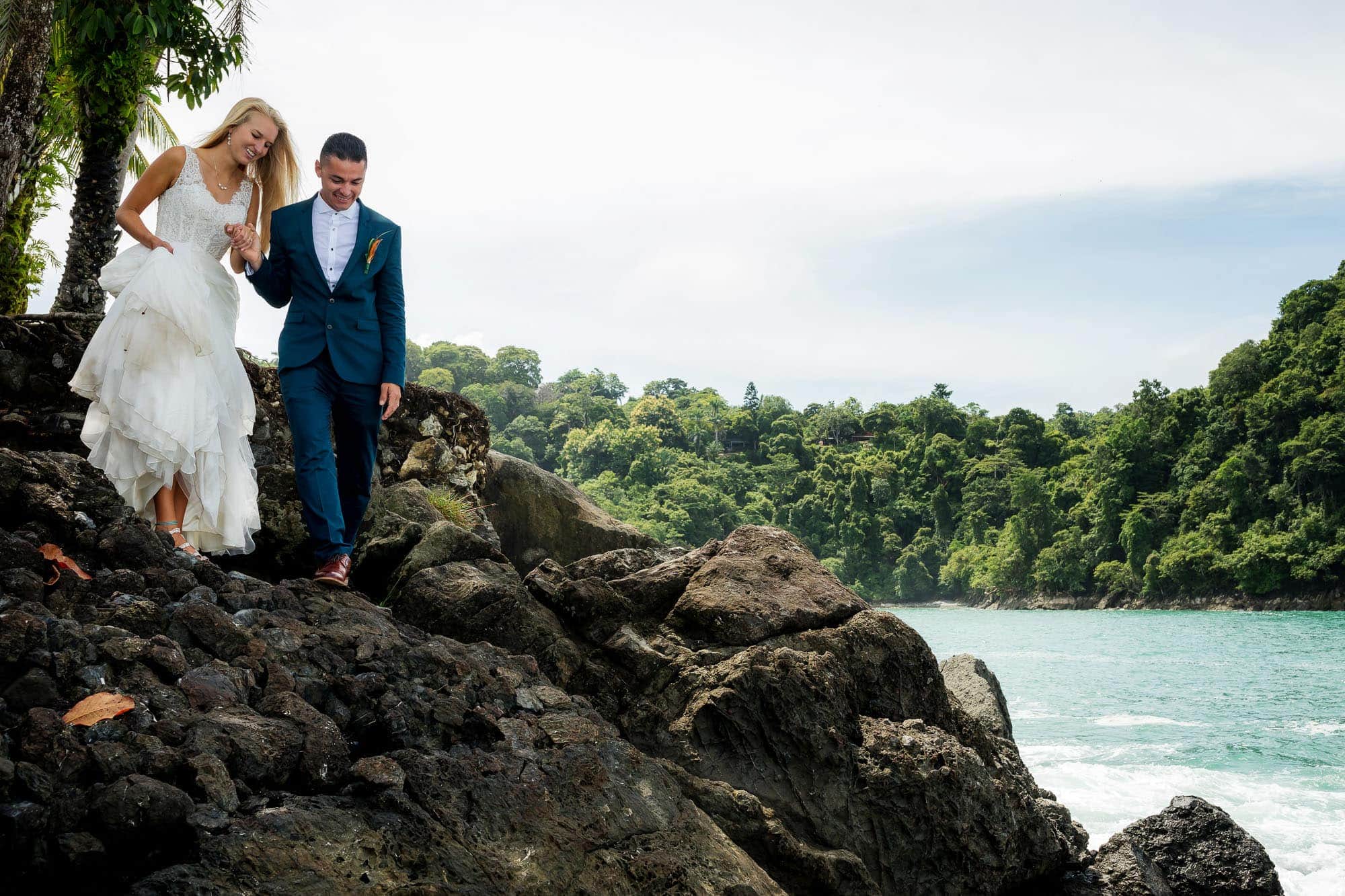 Bride and groom navigate the rocks at Nahomi for the day after their church wedding session