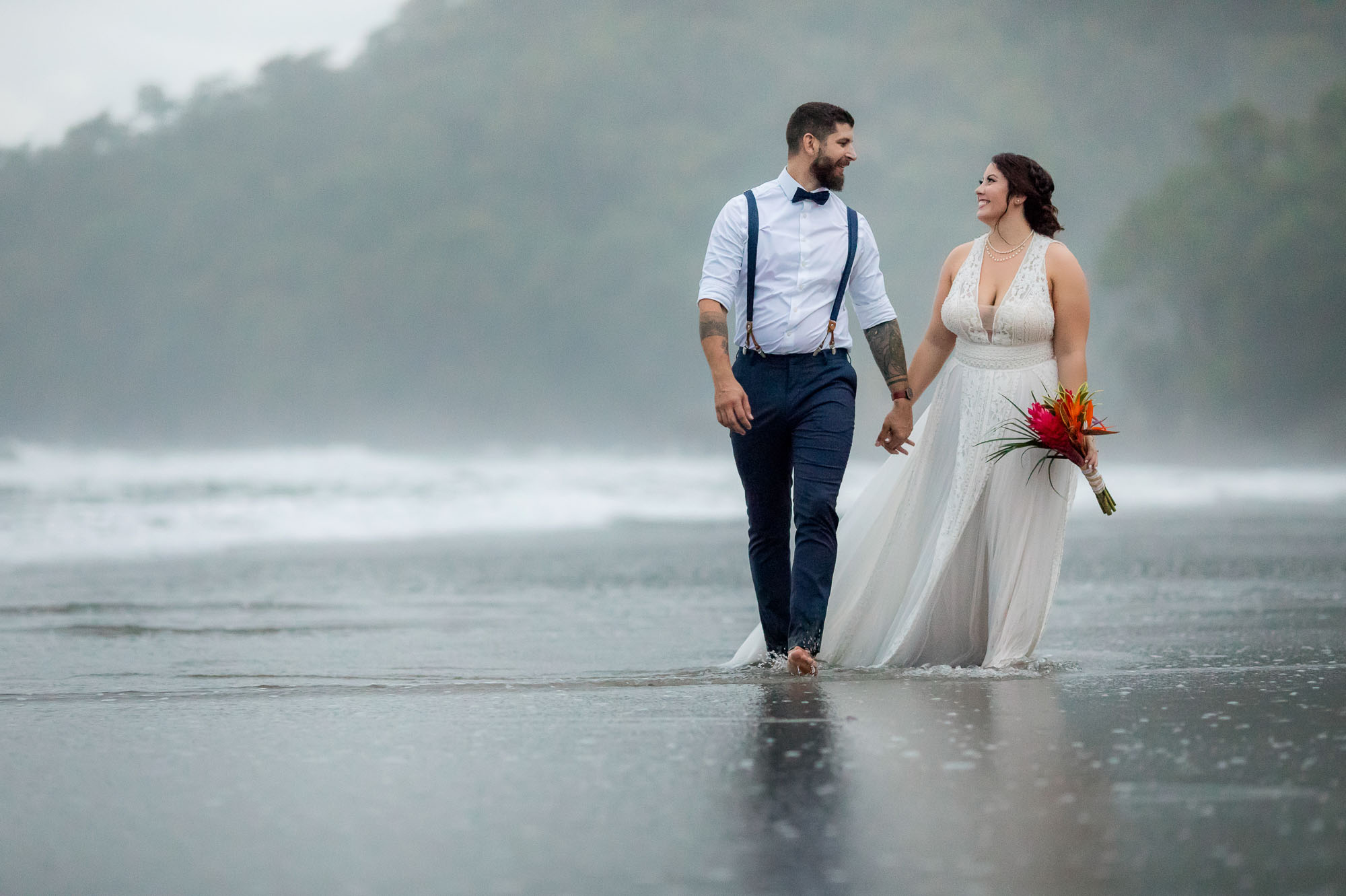Bride and groom walk along the beach for their elopement wedding