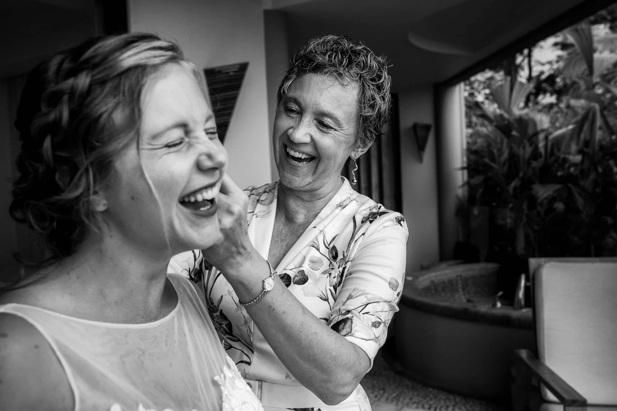 Mom laughing with the bride as she gets ready to get married