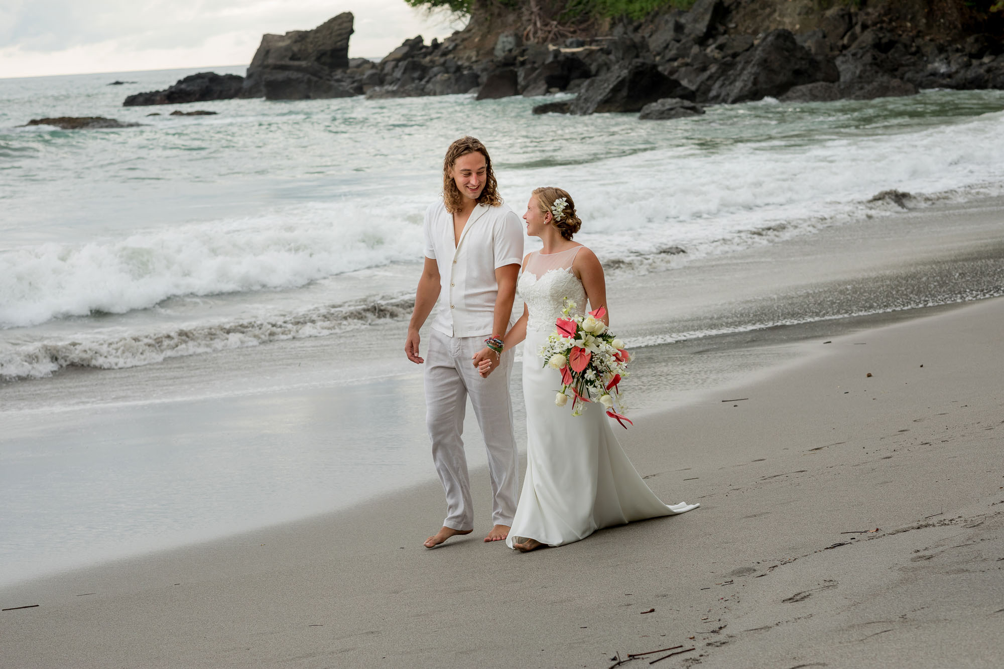 Bride and groom walking along the beach together