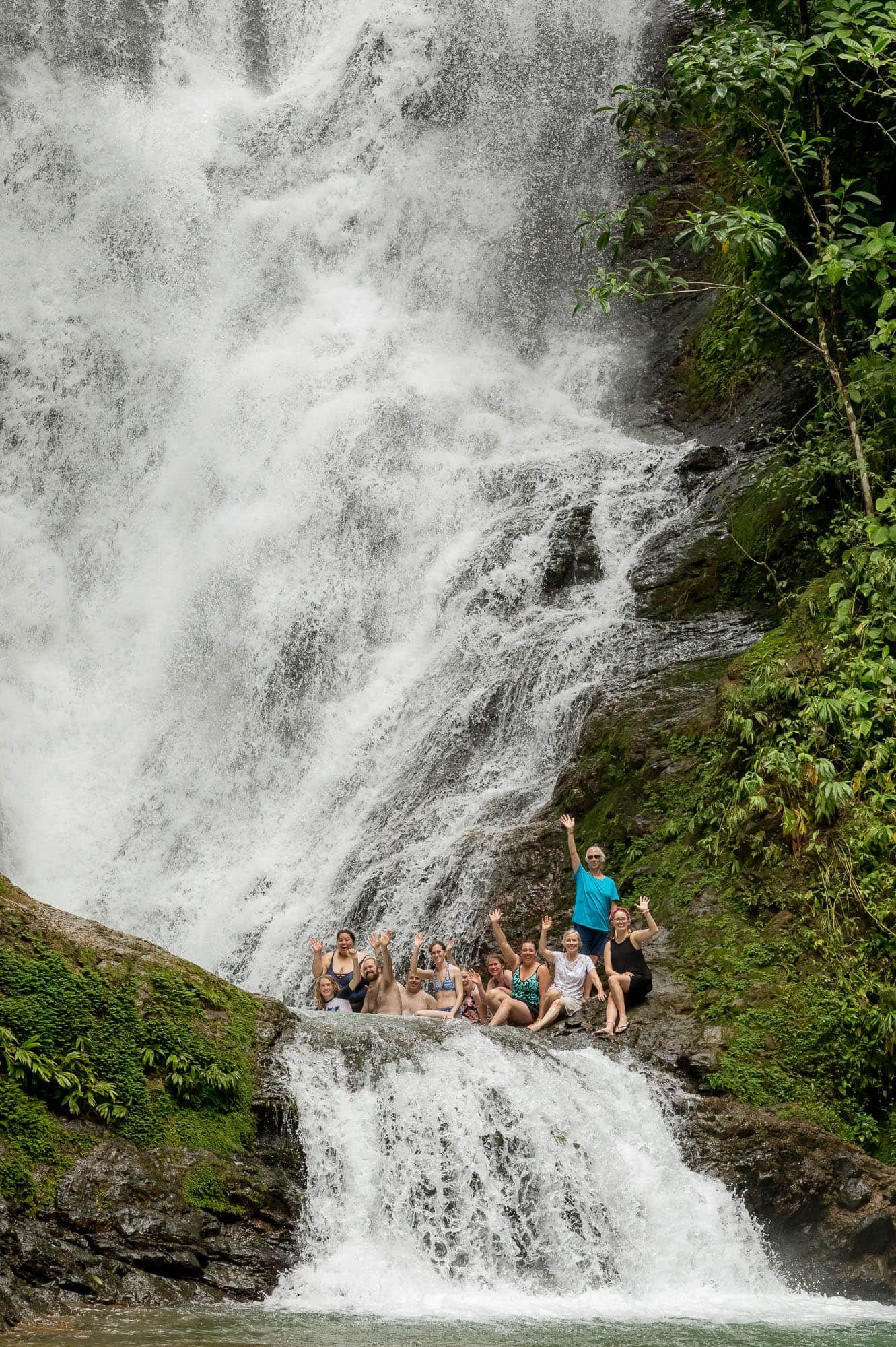 The wedding party off the beaten path in Costa Rica at the base of a waterfall