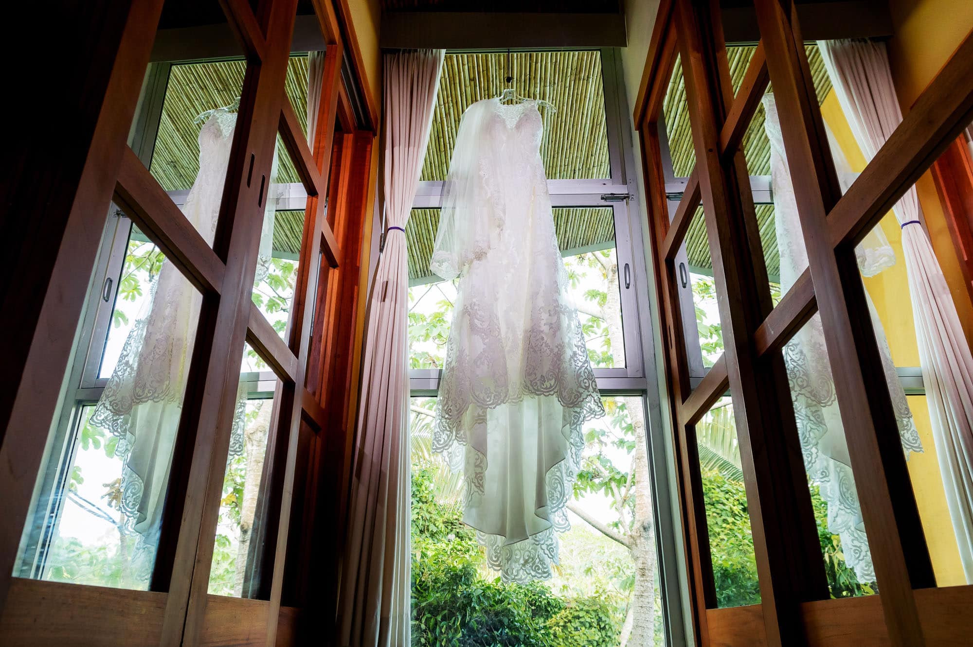 The wedding dress hanging in the window